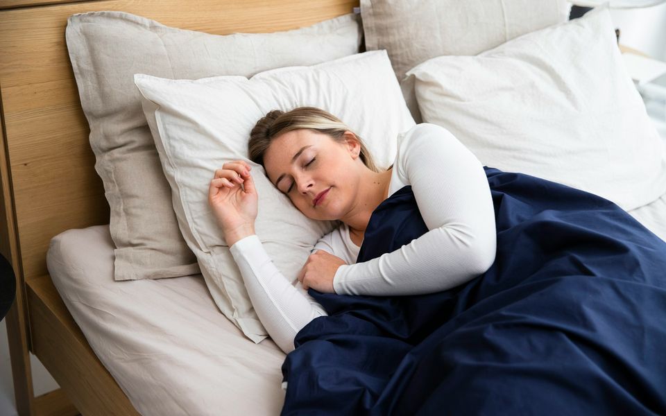 Frau schläft entspannt auf der Seite im Bett