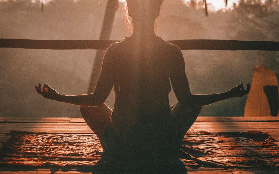 Frau meditiert im Sonnenlicht